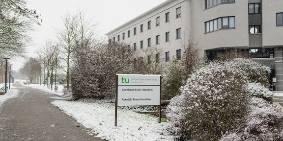 Das Gebäude der Fakultät Maschinenbau im Winter mit schneebedeckten Wegen.